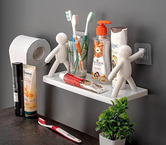 Bathroom organizer shelf for small spaces with toothbrushes, toothpaste, soap, and decorative figures mounted on wall