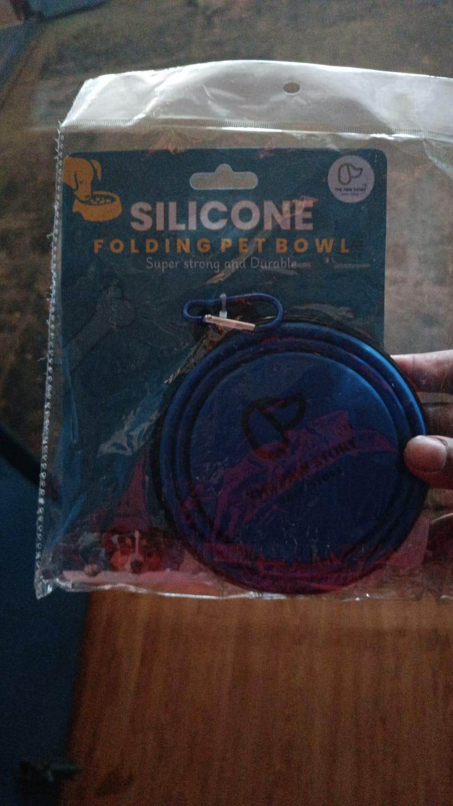 Foldable silicone pet bowl in blue with a metal carabiner clip for easy portability