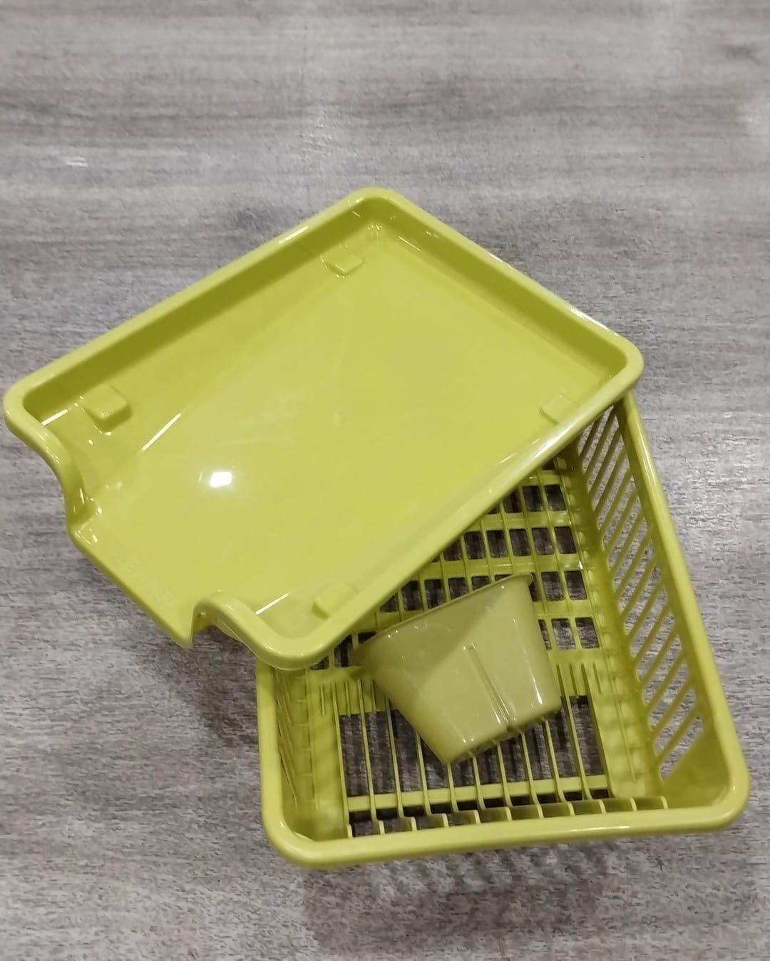 Yellow plastic kitchen dish drainer rack with utensil holder on gray surface