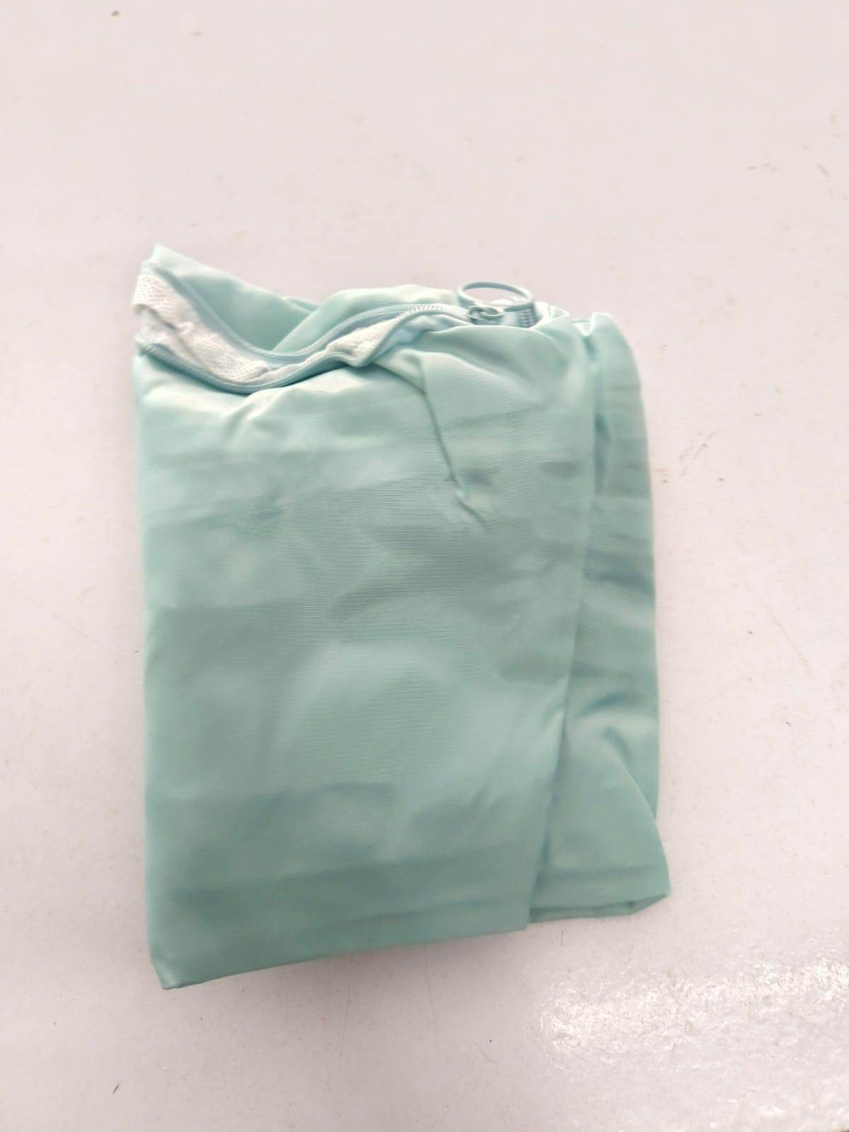 Folded light green space saving luggage organizer designed to maximize packing efficiency