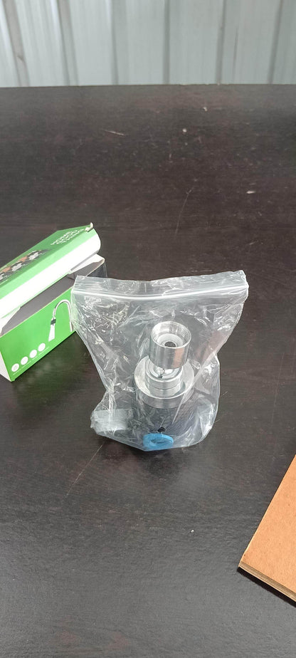 3 mode sink faucet nozzle in clear plastic packaging displayed on a dark surface next to a green and white box