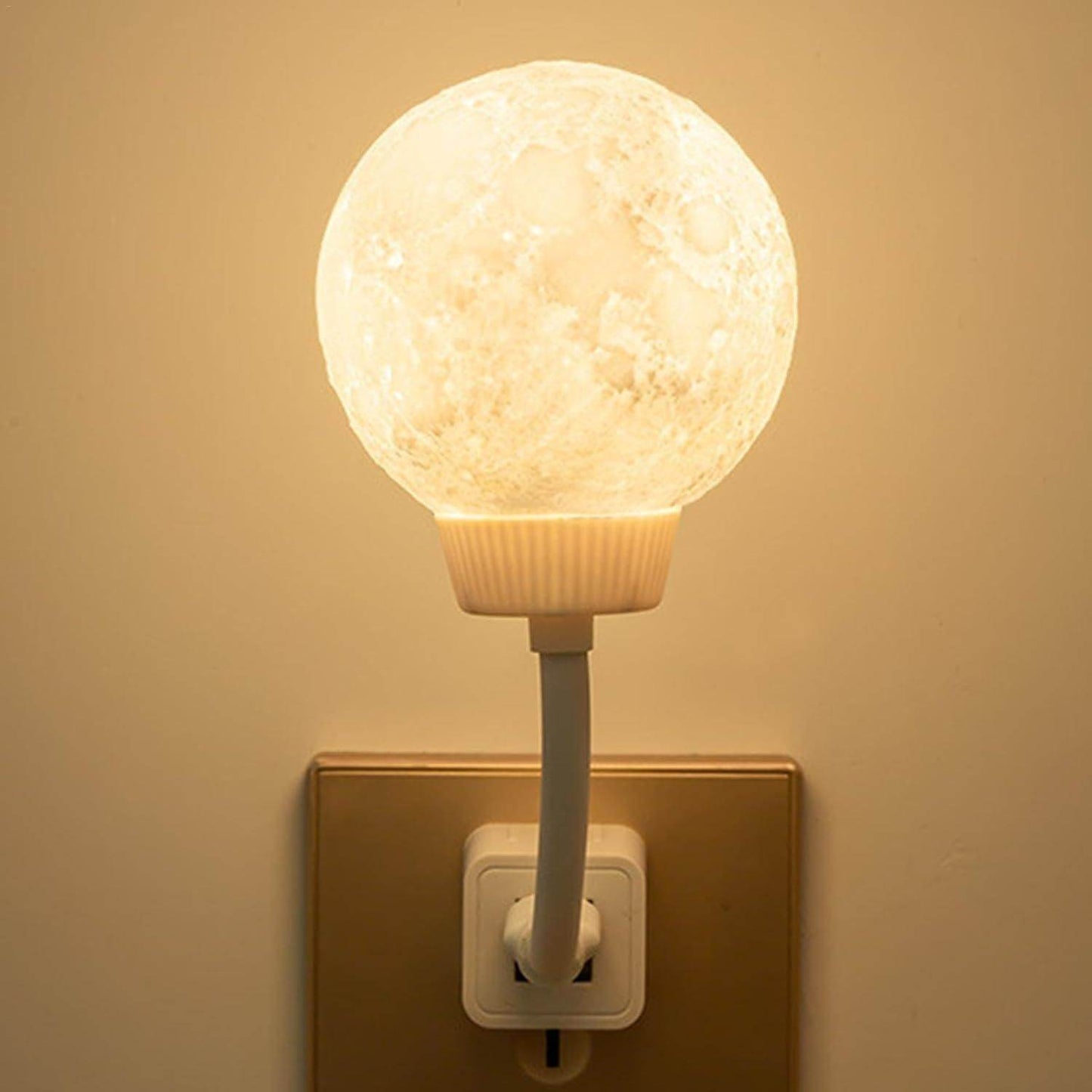 3D moon lamp night light plugged into wall outlet glowing with soft warm light