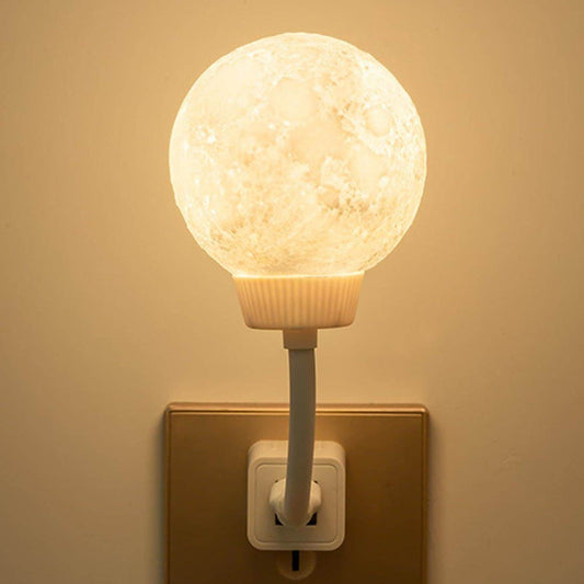 3D moon lamp night light plugged into wall outlet glowing with soft warm light