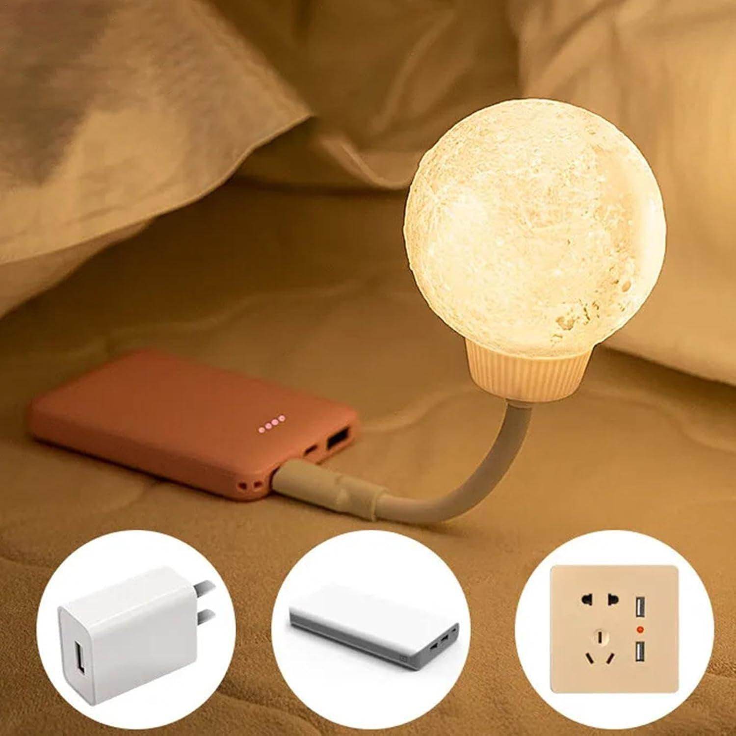 3D moon lamp night light glowing warmly on flexible stand connected to a power bank on bed
