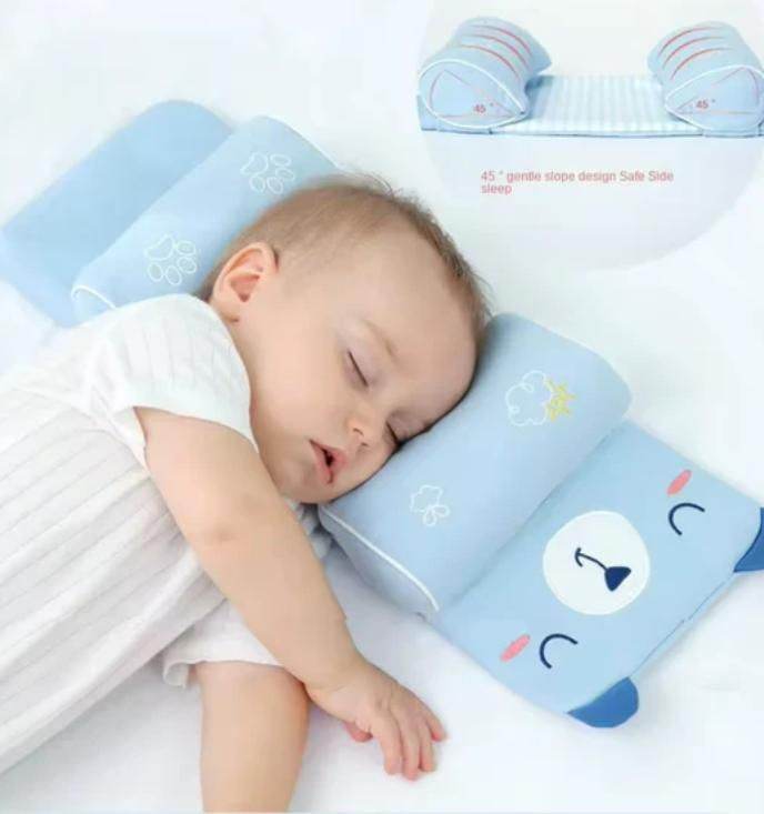 Baby sleeping on a blue baby head shaping pillow with a cute bear face design for safe side sleep