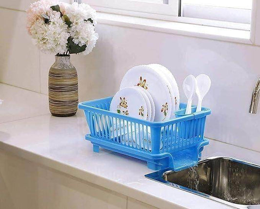 Blue kitchen dish drainer rack holding plates and utensils next to a kitchen sink on countertop