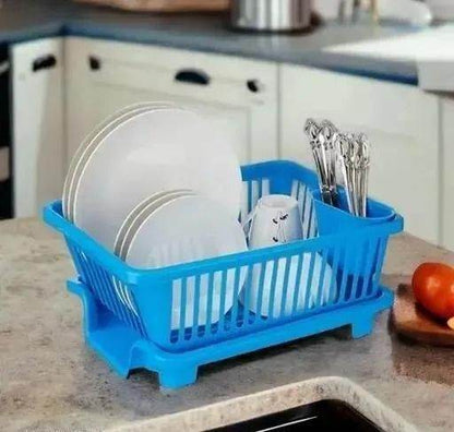Blue kitchen dish drainer rack holding white plates, cups, and silver utensils on countertop