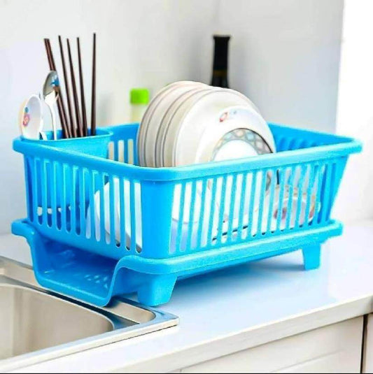 Blue kitchen dish drainer rack holding white plates and utensils next to kitchen sink