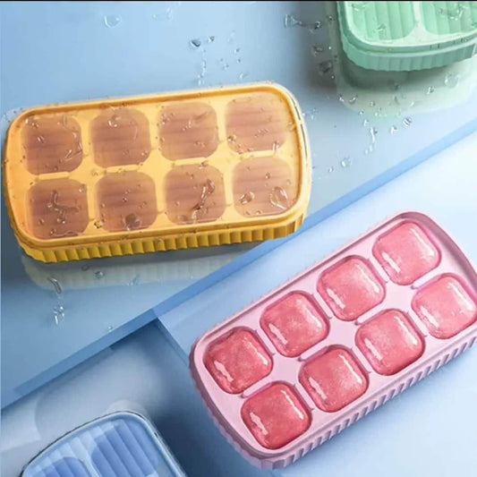 Colorful small ice cube mold for cocktails filled with water on a blue surface