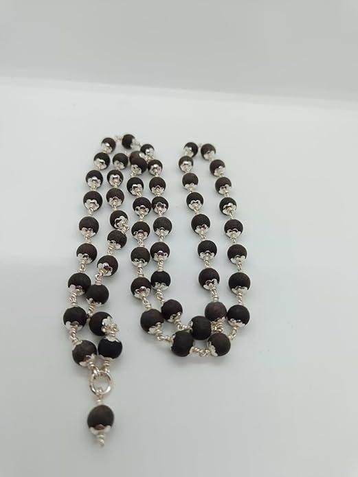 Ebony wood mala beads with dark polished beads and silver accents on a white background