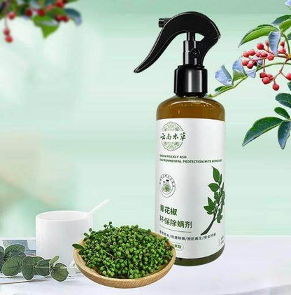 Eco-friendly anti-mite spray bottle with natural plant ingredients and green peppercorns on a white surface