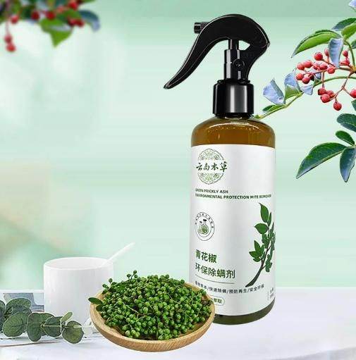 Eco-friendly anti-mite spray bottle with natural plant ingredients and green peppercorns on a white surface