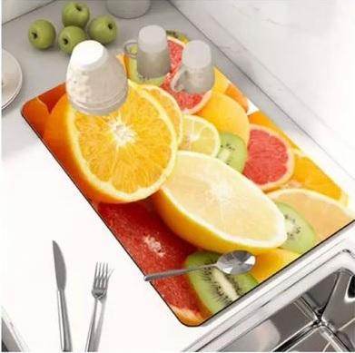 Colorful modern kitchen drying pad with vibrant citrus fruit design placed by the sink and utensils