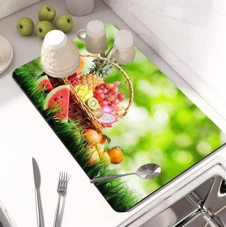 Modern kitchen drying pad with vibrant fruit basket design placed on white countertop by sink