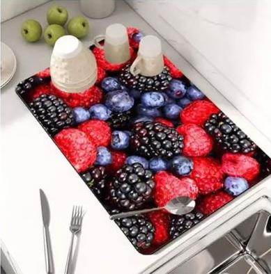 Modern kitchen drying pad with vibrant mixed berry design holding cups and utensils on countertop