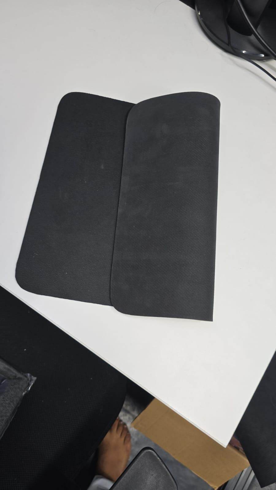 Black modern kitchen drying pad rolled open on white countertop showing smooth surface