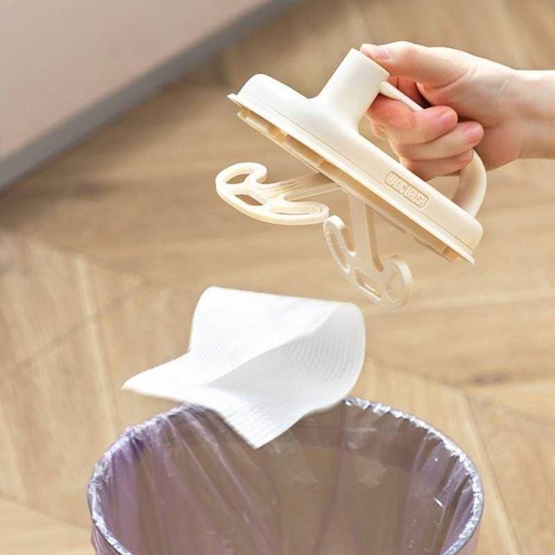 Hand holding a disposable cleaning brush with handle above a trash bin with paper towel