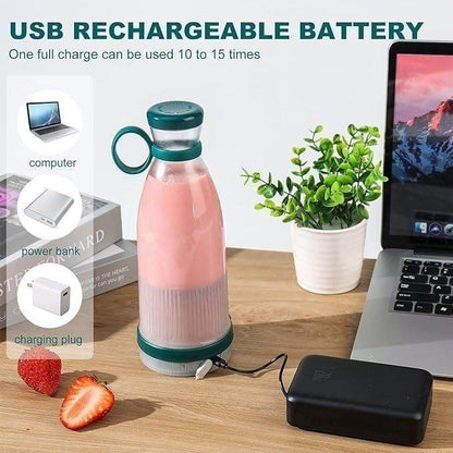 Portable mini juice blender with USB rechargeable battery charging beside laptop on wooden table