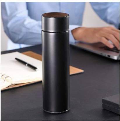 Black smart thermos bottle with temperature display on office desk near laptop and notebook